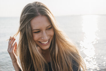 Portrait of happy young woman in front of the sea - KNSF00686