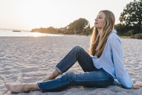 Junge Frau entspannt sich am Abend am Strand, lizenzfreies Stockfoto