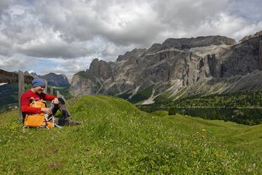 Italien, Südtirol, Dolomiten, Wanderer rastet auf einer Wiese in der Sellagruppe - LBF01519