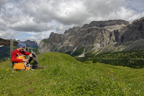 Italien, Südtirol, Dolomiten, Wanderer rastet auf einer Wiese in der Sellagruppe - LBF01519
