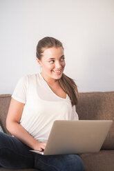 Young woman sitting the couch with laptop - SIPF01121