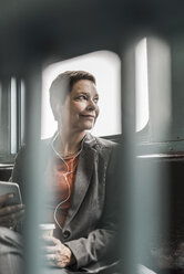 Businesswoman on a ferry looking out of window - UU09330