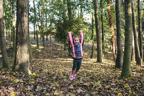 Glückliches kleines Mädchen, das im Wald in die Luft springt - DAPF00478