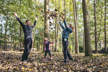 Happy family throwing autumn leaves in the air - DAPF00479