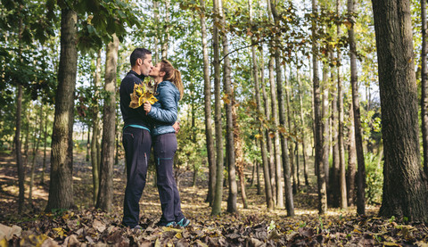 Küssendes Paar im herbstlichen Wald, lizenzfreies Stockfoto