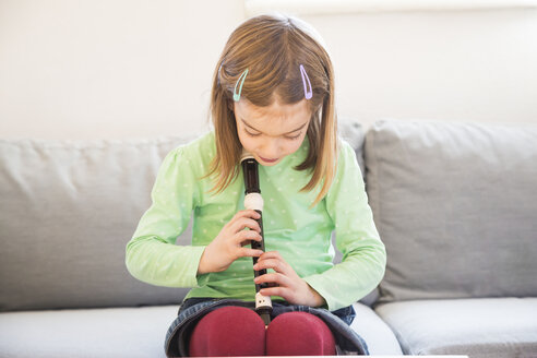Little girl sitting on couch with recorder - LVF05629