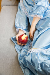 Kleines Mädchen, verkleidet als Prinzessin, hält einen angebissenen roten Apfel, Teilansicht - LVF05639
