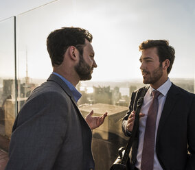 USA, New York City, two businessmen talking on Rockefeller Center observation deck - UU09354