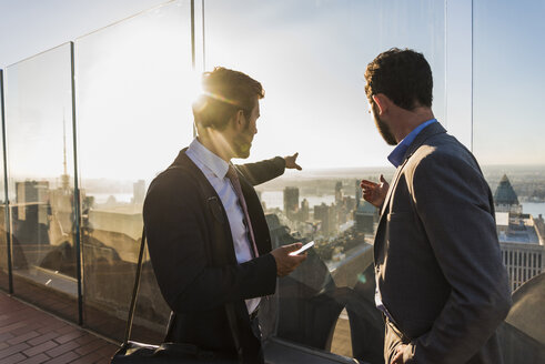 USA, New York City, two businessmen on Rockefeller Center observation deck - UU09356