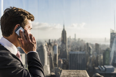 USA, New York City, Mann spricht auf der Aussichtsplattform des Rockefeller Center mit einem Handy - UU09360