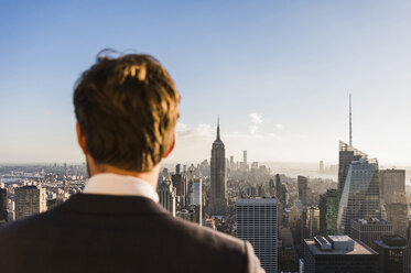 USA, New York City, man looking on cityscape on Rockefeller Center observation deck - UU09361