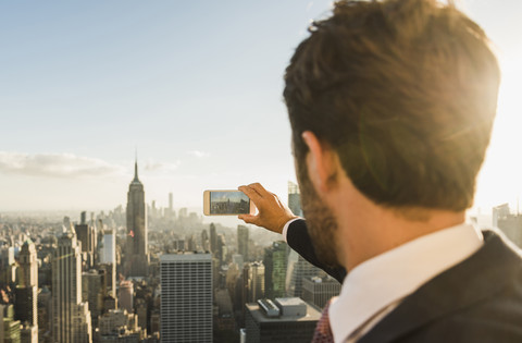 USA, New York City, Mann macht Handy-Foto auf der Aussichtsplattform des Rockefeller Center, lizenzfreies Stockfoto