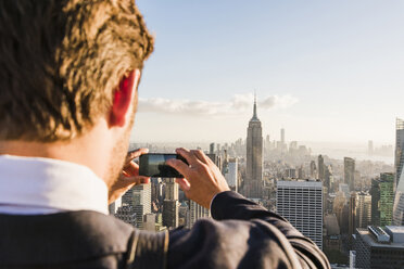 USA, New York City, Mann macht Handy-Foto auf der Aussichtsplattform des Rockefeller Center - UU09363
