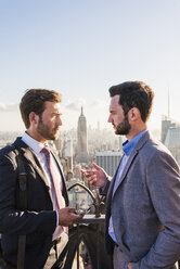 USA, New York City, two businessmen talking on Rockefeller Center observation deck - UU09366