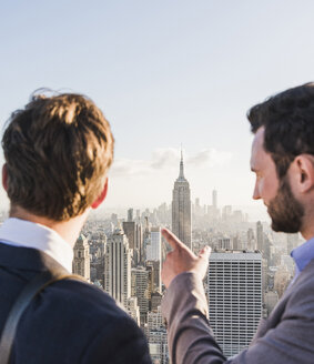 USA, New York City, zwei Geschäftsleute betrachten das Stadtbild auf der Aussichtsplattform des Rockefeller Center - UU09367