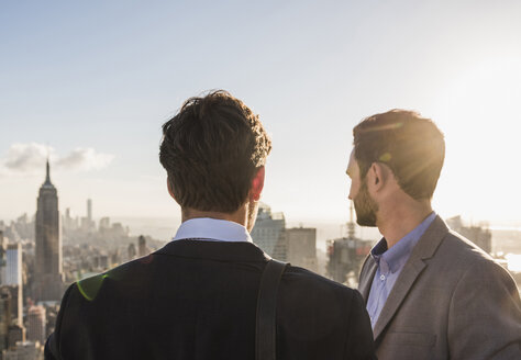 USA, New York City, zwei Geschäftsleute betrachten das Stadtbild auf der Aussichtsplattform des Rockefeller Center - UU09368