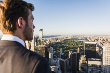 USA, New York City, man looking on cityscape on Rockefeller Center observation deck - UU09372