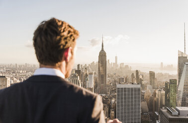 USA, New York City, man looking on cityscape on Rockefeller Center observation deck - UU09374