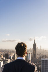 USA, New York City, man looking on cityscape on Rockefeller Center observation deck - UU09375