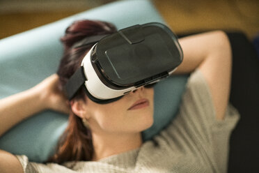 Young woman using Virtual Reality Glasses at home - TAMF00848