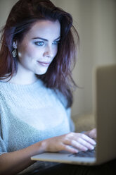 Young woman using laptop at home - TAMF00849