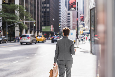 USA, New York City, Geschäftsfrau in Manhattan, die unterwegs ist, lizenzfreies Stockfoto