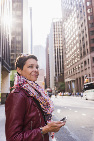 USA, New York City, lächelnde Frau in Manhattan, lizenzfreies Stockfoto