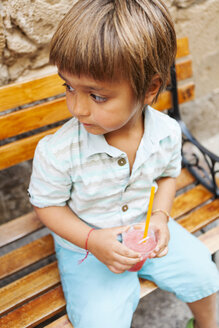 Kleiner Junge mit gekühltem Erfrischungsgetränk auf einer Holzbank sitzend - VABF00845