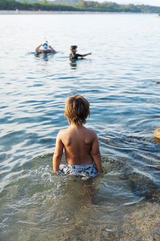 Rückenansicht eines kleinen Jungen im Meer, lizenzfreies Stockfoto