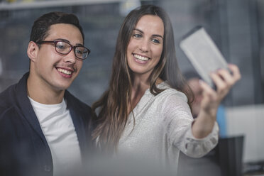 Porträt von lächelnden Geschäftsleuten, die ein Selfie im Büro machen - ZEF11838