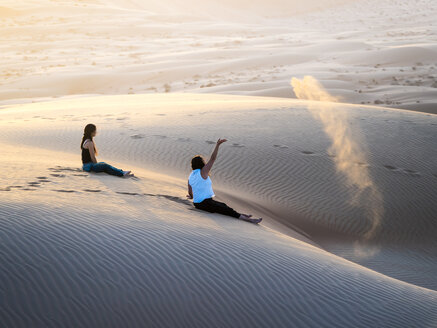 Oman, Al Raka, zwei junge Frauen sitzen auf einer Düne in der Wüste Rimal Al Wahiba - AMF05100