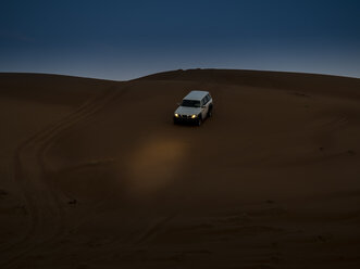 Oman, Al Raka, off-road vehicle parking on dune in Rimal Al Wahiba desert at twilight - AMF05105