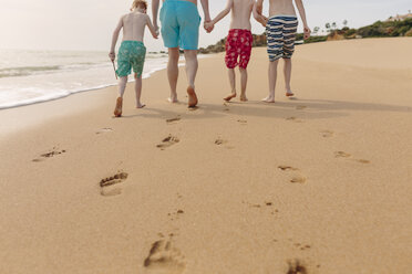 Father and sons walking on the beach - NMSF00002