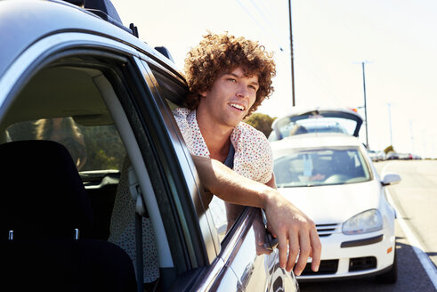 Lächelnder junger Mann schaut aus dem Autofenster - WESTF21977