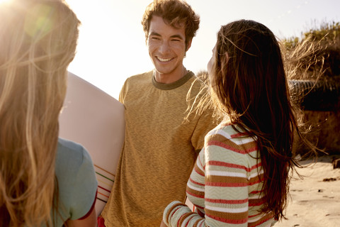 Freunde mit Surfbrett am Strand, lizenzfreies Stockfoto