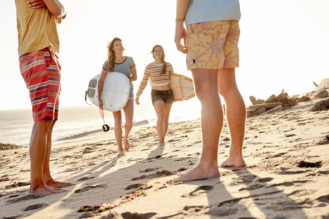 Glückliche Freunde mit Surfbrettern am Strand, lizenzfreies Stockfoto