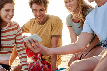 Glückliche Freunde mit Handy am Strand - WESTF22054