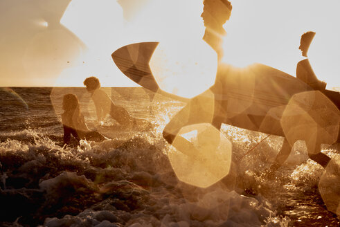 Surfer laufen bei Sonnenuntergang ins Meer - WESTF22067