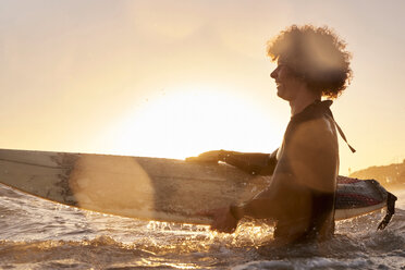 Happy surfer in the sea at sunset - WESTF22069