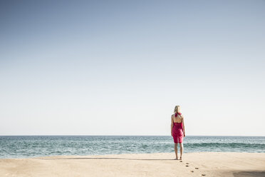 Rückenansicht einer Frau, die am Strand spazieren geht - CHPF00356