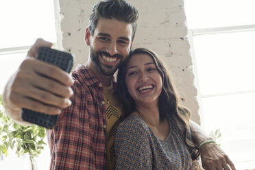 Glückliches junges Paar macht ein Selfie in einem Loft - WESTF22118