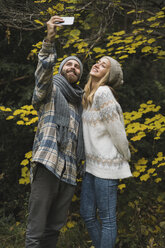 Young couple outdoors in autumn taking a selfie - KKAF00091