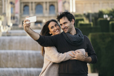 Spain, Barcelona, couple in love taking selfie with cell phone - KKAF00116