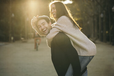 Couple having fun together in a park at evening twilight - KKAF00123