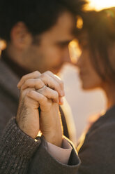 Couple holding hands at sunset, close-up - KKAF00139