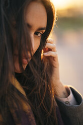Portrait of woman with brown hair at sunset - KKAF00143