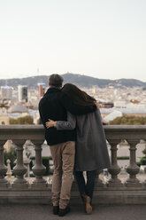 Spain, Barcelona, back view of couple arm in arm looking at the city - KKAF00147