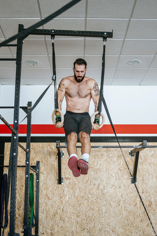 Mann macht Übungen an Ringen im Fitnessstudio, lizenzfreies Stockfoto