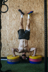 Man doing a handstand on weights - KIJF00978