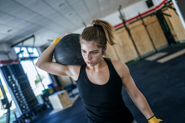 Frau trainiert mit Ball im Fitnessstudio - KIJF00984